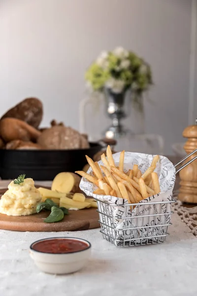 French fries dish with sauces and vegetables on table.