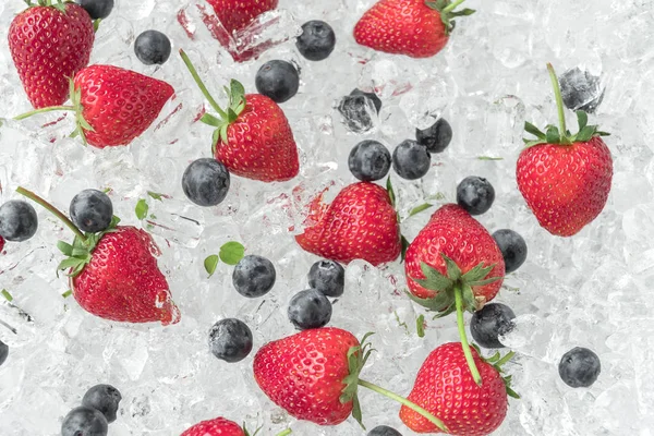 Seamless pattern of strawberries with blueberries on ice