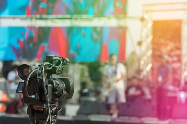 Video production covering event on stage by professional video camera in outdoor concert.