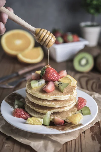 Buckwheat pancakes with berries, fruits and honey. Selective focus.