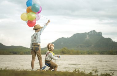 Mutlu çocuk ve kardeşi balonları, yaz büyük tatil zamanında sahip plaj renkli balonlar ile çalış. Yaşam tarzı, tatil, mutluluk, sevinç kavramı