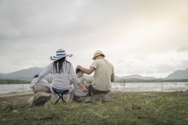 Genç kızı ve oğluyla yakın göl piknik üzerinde üst. Aile kavramları