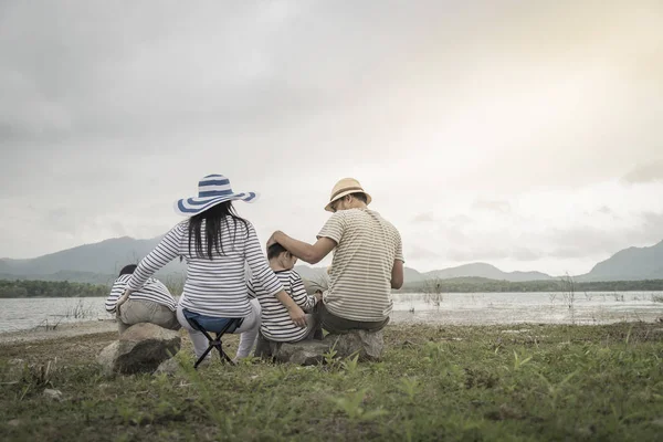 Genç kızı ve oğluyla yakın göl piknik üzerinde üst. Aile kavramları