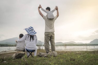 Genç kızı ve oğluyla yakın göl piknik üzerinde üst. Aile kavramları