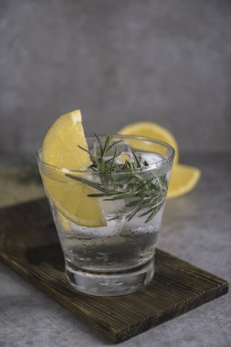 Alkollü içki cin tonik limon, biberiye ve buz üzerinde tablo.