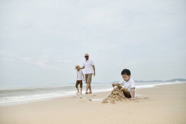 Mutlu bir aile babası ile iki oğlu sahil üzerinde oynama