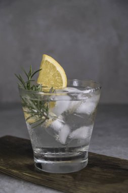 Cin tonik kokteyl limon, biberiye ve tablo buza gıda kompozisyonu.