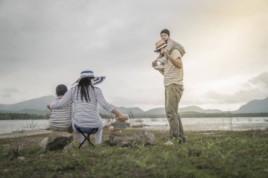 Genç kızı ve oğluyla yakın göl piknik üzerinde üst. Aile kavramları