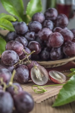 Ahşap masa yemeye hazır tabağa hasır sağlıklı kırmızı üzüm.