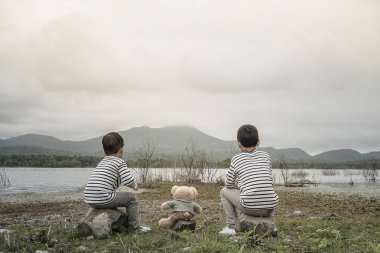 Çocuk sitesi oturan bir oyuncak ayı ile Asya havzanın arka plan olduğunu. Tayland.