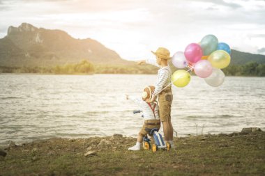 İki küçük Asya çocuklar balonları sahilde büyük tatil vakit geçiriyor.
