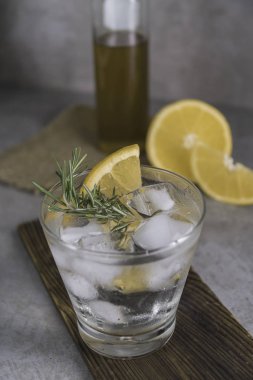 Tablo üzerinde alkollü içki cin tonik limon, biberiye ve buz ile görünümü Kapat.