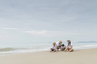 Asyalı erkek ve kadın ile iki oğlu beach resort üzerinde oynama