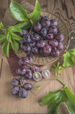 Ahşap masa yemeye hazır tabağa hasır sağlıklı kırmızı üzüm.