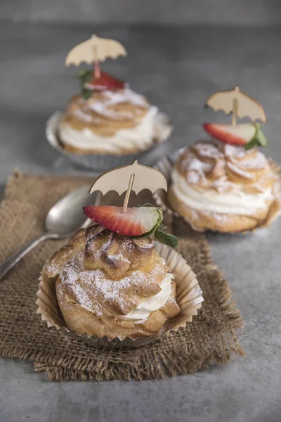 Krema, çilek ve nane ile ev yapımı profiterol görünümü Kapat.