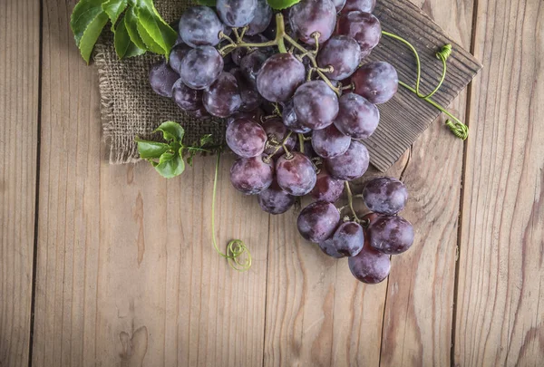 Ahşap masa üzerinde sağlıklı kırmızı üzüm üstten görünüm.