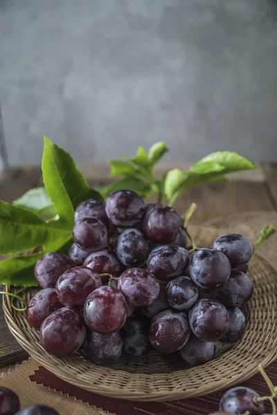 Natürmort ahşap masa üzerinde sağlıklı kırmızı üzüm.