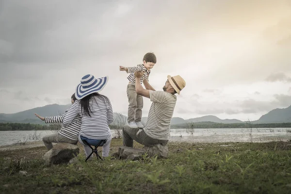 Genç kızı ve oğluyla yakın göl piknik üzerinde üst. Aile kavramları