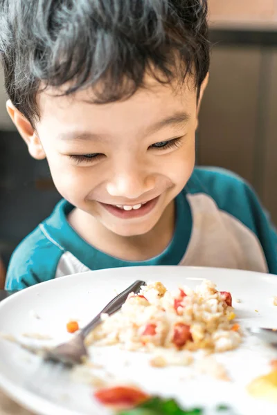 Asian boy looking at food at home/