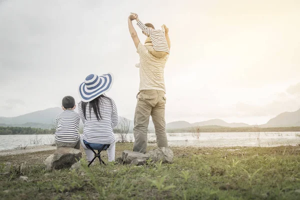 Genç kızı ve oğluyla yakın göl piknik üzerinde üst. Aile kavramları