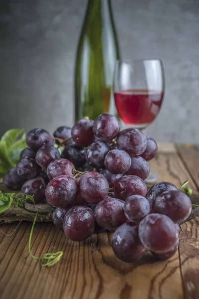 Gıda kompozisyon kırmızı üzüm şarap arka plan üzerinde ahşap tablo.
