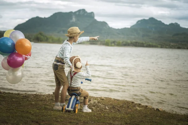 İki küçük Asya çocuklar balonları sahilde büyük tatil vakit geçiriyor.