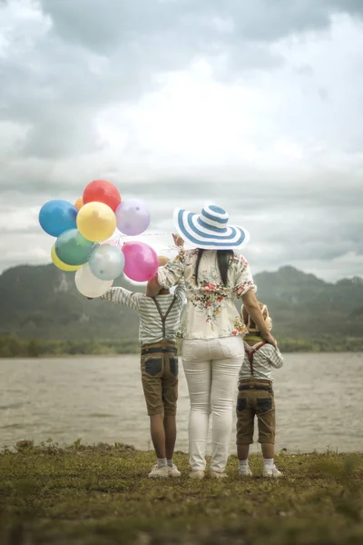 Bakifrån Asiatisk Kvinna Kramas Söner Stående Stranden Med Ballonger — Stockfoto