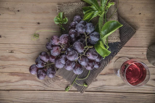 Ahşap masa üzerinde sağlıklı kırmızı üzüm demet.