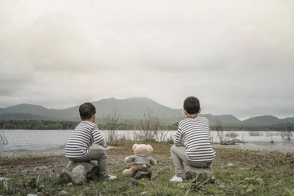 Çocuk sitesi oturan bir oyuncak ayı ile Asya havzanın arka plan olduğunu. Tayland.