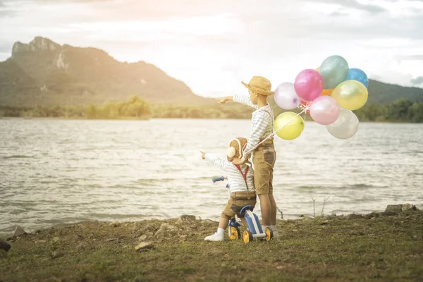 İki küçük Asya çocuklar balonları sahilde büyük tatil vakit geçiriyor.