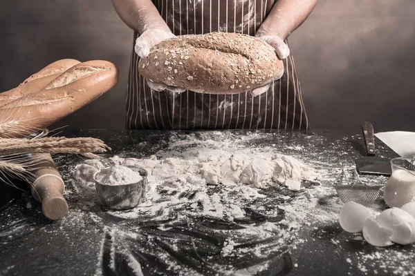 Adam ekmek, mutfak masasının üzerinde taze hamur üzerine un yağmurlama adam tabloda buns hazırlanıyor