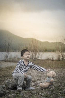 Çocuk sitesi oturan bir oyuncak ayı ile Asya havzanın arka plan olduğunu. Tayland.