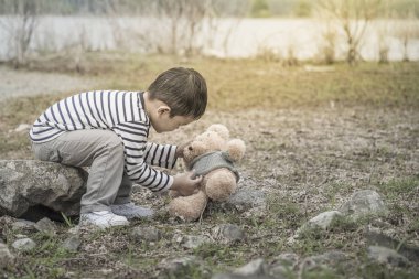 Çocuk sitesi oturan bir oyuncak ayı ile Asya havzanın arka plan olduğunu. Tayland.