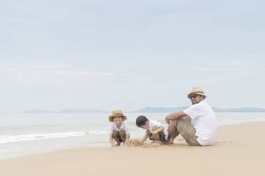 Mutlu bir aile babası ile iki oğlu sahil üzerinde oynama