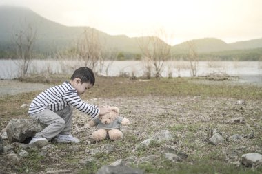 Çocuk sitesi oturan bir oyuncak ayı ile Asya havzanın arka plan olduğunu. Tayland.