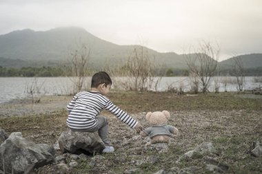 Çocuk sitesi oturan bir oyuncak ayı ile Asya havzanın arka plan olduğunu. Tayland.