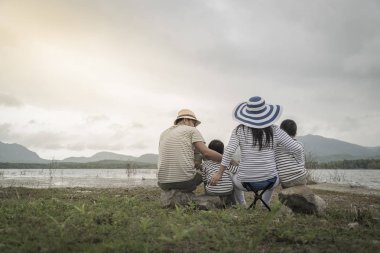 Genç kızı ve oğluyla yakın göl piknik üzerinde üst. Aile kavramları