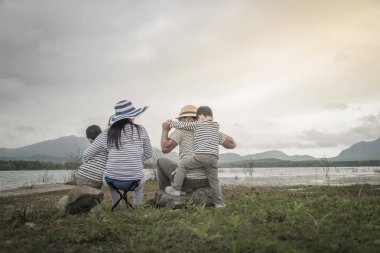 Genç kızı ve oğluyla yakın göl piknik üzerinde üst. Aile kavramları