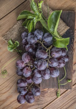 Ahşap masa üzerinde sağlıklı kırmızı üzüm üstten görünüm.