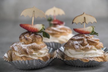 Krema, çilek ve nane ile ev yapımı profiterol görünümü Kapat.