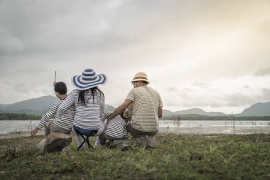 Genç kızı ve oğluyla yakın göl piknik üzerinde üst. Aile kavramları