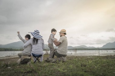 Genç kızı ve oğluyla yakın göl piknik üzerinde üst. Aile kavramları