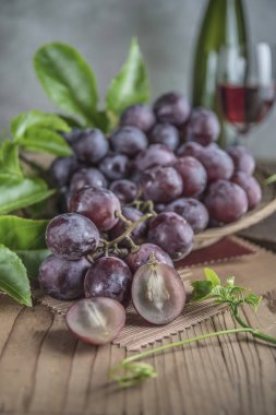 Ahşap masa yemeye hazır tabağa hasır sağlıklı kırmızı üzüm.