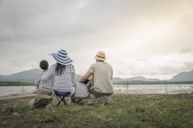 Genç kızı ve oğluyla yakın göl piknik üzerinde üst. Aile kavramları