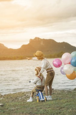 Mutlu çocuk ve kardeşi balonları, yaz büyük tatil zamanında sahip plaj renkli balonlar ile çalış. Yaşam tarzı, tatil, mutluluk, sevinç kavramı