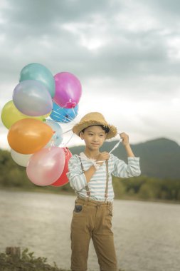 Mutlu çocuk renkli balonlarla yaz büyük tatil zamanında sahip plaj üzerinde çalış. Yaşam tarzı, tatil, mutluluk, sevinç kavramı