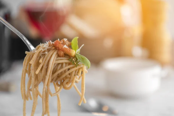 Fork with spaghetti topped with delicious bolognaise sauce and basil