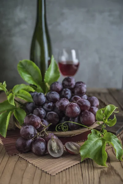 Natürmort kırmızı üzüm şarap arka plan üzerinde ahşap tablo.