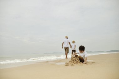 mutlu aile sahilde iki çocukla, deniz üzerinde mutlu aile beach Resort'ta