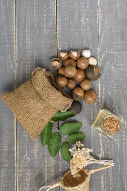 Macadamia fıstığı saçılan petrol şişe ahşap arka plan üzerinde olan torba.